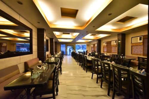 a dining room with tables and chairs in a restaurant at Tekareesinn in Lucknow