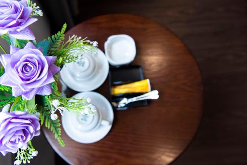 a wooden table with a vase of purple flowers on it at Gia Phong Hotel in Xóm Niêm