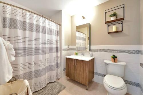 La salle de bains est pourvue de toilettes, d'un lavabo et d'un miroir. dans l'établissement Elegant Main Street Living* Near NYC, à Hackensack