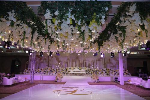a wedding hall with white flowers and tables and chairs at Millennium Plaza Downtown Suites in Dubai