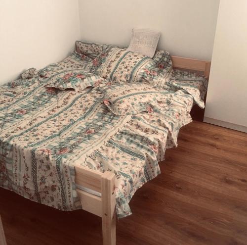 a bed with a quilt on it in a bedroom at Siedlisko u Agi in Ryn