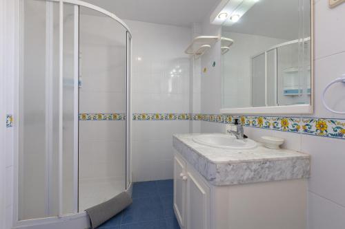 a white bathroom with a sink and a shower at Carihuela beach in Torremolinos