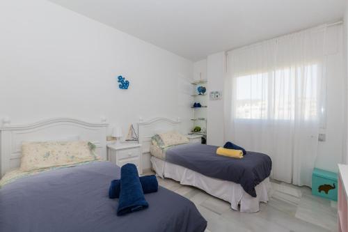 a bedroom with two beds and a window at Carihuela beach in Torremolinos