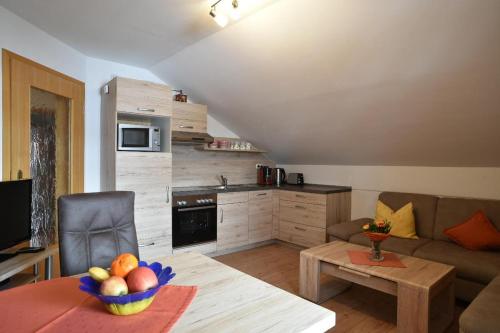 a living room with a couch and a table with a bowl of fruit at Ferienwohnungen Haus Rachel in Neuschönau