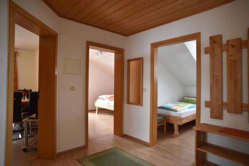 een kamer met 2 spiegels en een slaapkamer met een bed bij Ferienwohnungen Haus Rachel in Neuschönau