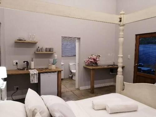 a living room with a couch and a table and a kitchen at Cooper Cottage in Howick