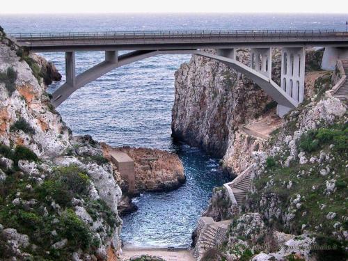 a bridge over a river on the side of a cliff at Casa Fadea in Gagliano del Capo
