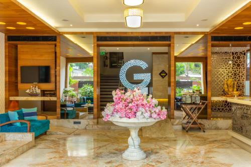 a lobby with a large bowl of flowers in a fountain at HOTEL G EXPRESS Formerly Known as TGB Express in Ahmedabad