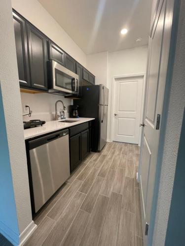 een keuken met zwarte kasten en witte apparaten bij Cozy suites 4 less in Haines City