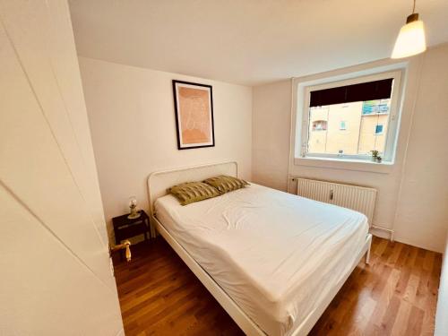 a small bedroom with a bed and a window at Apartment in the heart of Aalborg in Aalborg