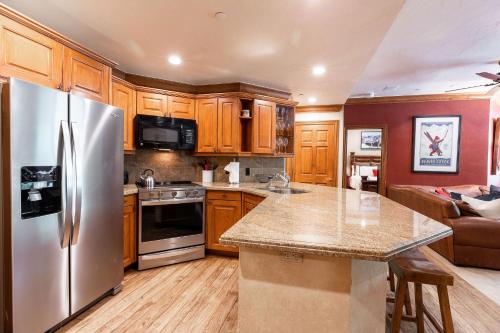a kitchen with stainless steel appliances and wooden cabinets at Strawberry Park Ski-in Ski-Out Condo Close to Chairlift in Beaver Creek