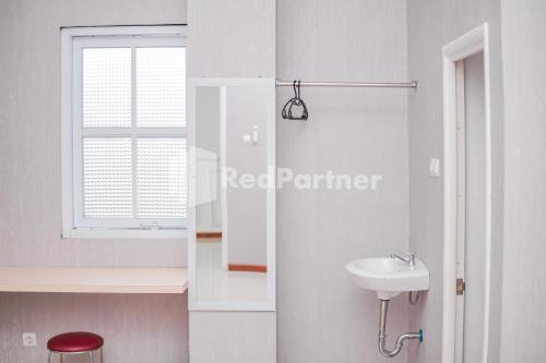 a white bathroom with a sink and a window at DManggo Guest House Syariah RedPartner in Tasikmalaya