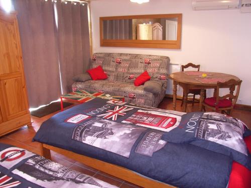 ein Wohnzimmer mit einem Bett und einer Couch in der Unterkunft Studio aux Eyzies au coeur de la vallée de l'homme in Le Repaire