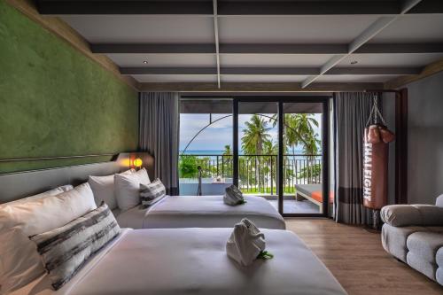 um quarto de hotel com duas camas e uma varanda em Thai Fight Hotel em Lamai