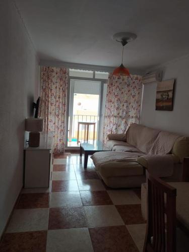 un soggiorno con un divano e una finestra di Apartamento grumete a El Puerto de Santa María