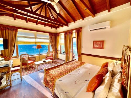 ein Schlafzimmer mit einem Bett und ein Wohnzimmer mit einem Fenster in der Unterkunft The Fishermen's Lodge by Leisure Hotels in Bhīm Tāl