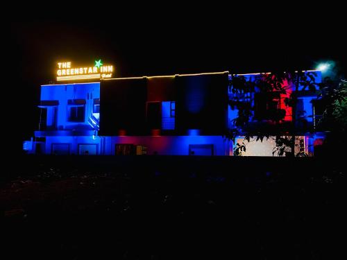 a building with a neon sign on it at night at THE GREENSTAR INN PREMIUM in Bhubaneshwar