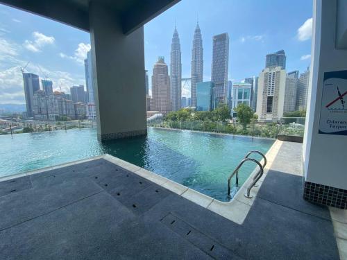 een zwembad met uitzicht op de skyline van de stad bij Legasi Kampung Baru by Twenty7 in Kuala Lumpur