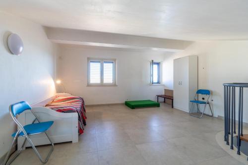 um quarto com uma cama e duas cadeiras em Villetta a mare Licata em Licata