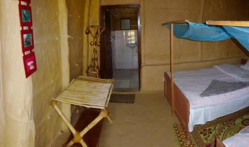a bedroom with a bed and a chair in it at Bardia Eco Lodge in Bardia