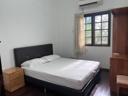 Schlafzimmer mit einem Bett und einem Fenster in der Unterkunft Titi Panjang Apartment Lumut Sitiawan Manjung in Lumut