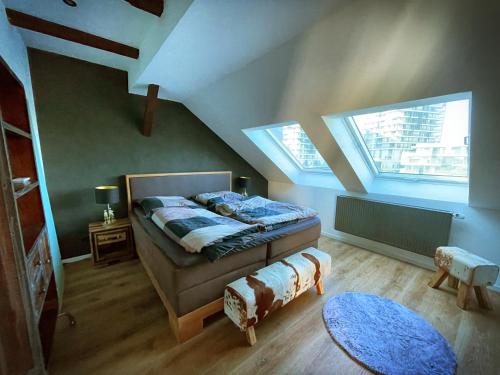 een slaapkamer met een bed en 2 ramen bij Studio Hundertwasser in Erfurt
