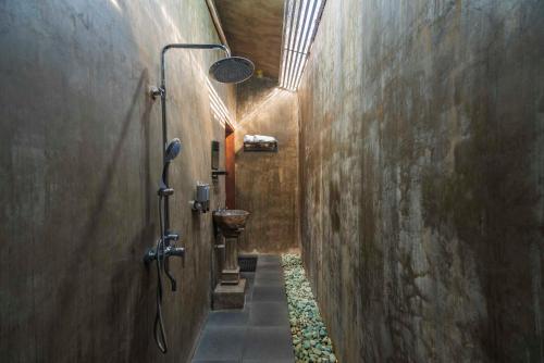 un corridoio di un bagno con doccia e lavandino di Elemento Homestay Badung a Bringkit