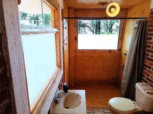 ein kleines Bad mit einem WC und einem Fenster in der Unterkunft Cabaña para pareja en el bosque IB in Acaxochitlán