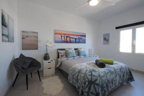 um quarto com uma cama e uma cadeira em Private apartment with mountain and sea views, La Asomada, Lanzarote em Tías