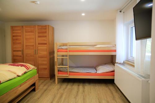 a small bedroom with two bunk beds and a window at Ferienhaus Crosta Brava in Großdubrau