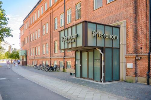 a brick building with a sign for a store at Forenom Aparthotel Malmö Varvsstaden in Malmö