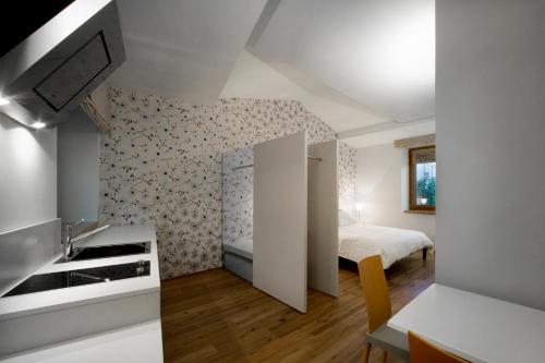1 dormitorio pequeño con 1 cama y cocina en Le Civette, en Morro dʼAlba