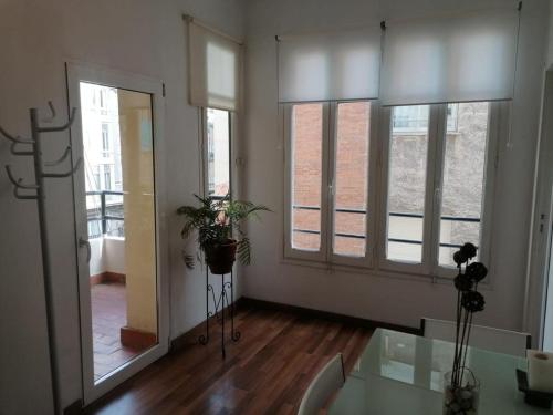 a room with three windows and a glass table at Apartamento con encanto Mila VALENCIAYOLE in Valencia