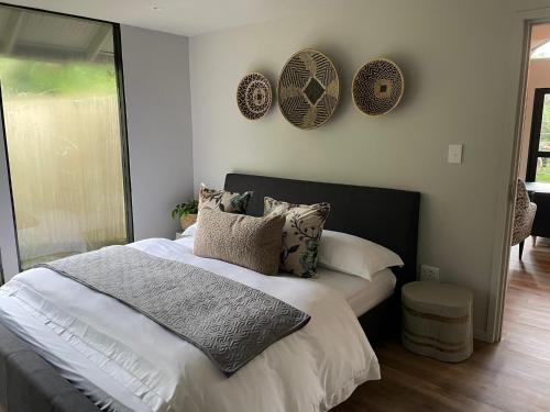 a bedroom with a bed with pillows and plates on the wall at Tinswari Self-catering Chalet in Hluhluwe