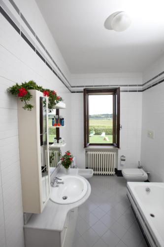 a white bathroom with two sinks and two toilets at Bed & Breakfast Conca Verde in Cavriana