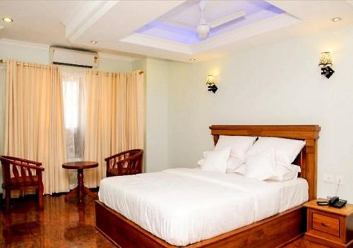 a bedroom with a bed and a table and chairs at Sea Breeze Beach Inn in Kannur