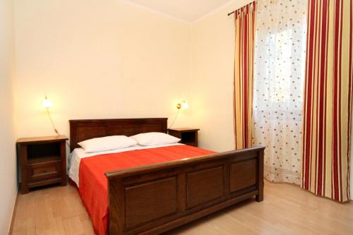 a bedroom with a large bed with a red blanket at Secluded family friendly house Kapelica, Labin - 5536 in Raša