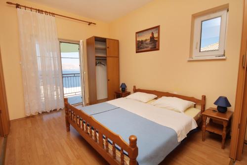 a bedroom with a large bed and a balcony at Apartments and rooms with WiFi Senj - 5560 in Senj