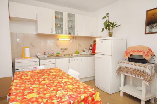 a kitchen with a table and a white refrigerator at Apartments with a parking space Bol, Brac - 5605 in Bol