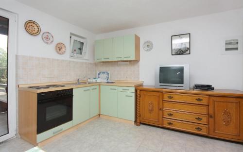 a kitchen with a stove and a tv on a counter at Apartments by the sea Splitska, Brac - 5664 in Splitska