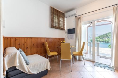 a bedroom with a bed and a table and chairs at Apartments by the sea Pucisca, Brac - 5625 in Pučišća