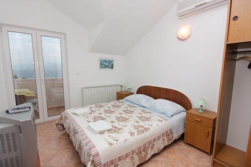 a small bedroom with a bed and a window at Apartments by the sea Splitska, Brac - 5664 in Splitska