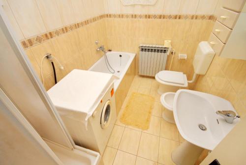 a bathroom with a white sink and a toilet at Apartments with parking space Senj - 5572 in Senj