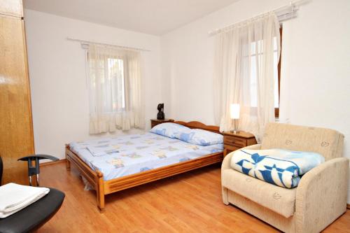 セニにあるApartments by the sea Senj - 5570のベッドと椅子のある寝室