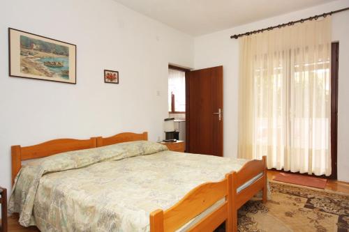 1 dormitorio con cama y ventana en Apartments with WiFi Supetar, Brac - 5667, en Supetar
