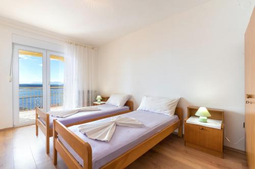 1 dormitorio con 2 camas y ventana en Apartments with a parking space Dramalj, Crikvenica - 5592, en Dramalj