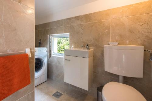 a bathroom with a sink and a washing machine at Apartments with a parking space Dramalj, Crikvenica - 5592 in Dramalj
