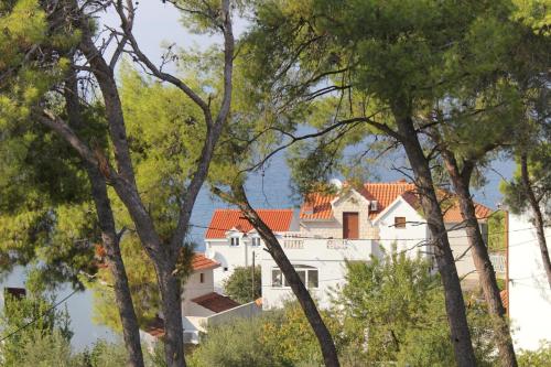 a white house seen through the trees at Apartments with a parking space Sutivan, Brac - 5629 in Sutivan