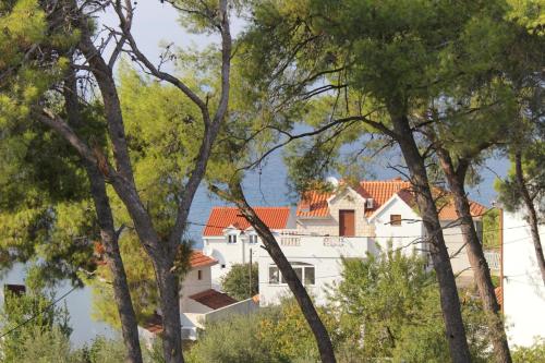 a white house seen through the trees at Apartments with parking space Sutivan, Brac - 5629 in Sutivan