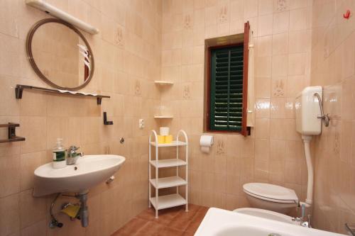a bathroom with a sink and a toilet and a mirror at Apartments by the sea Mirca, Brac - 5655 in Mirce